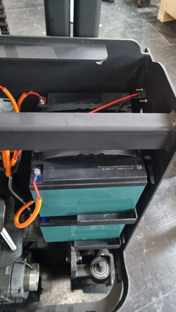 Compartimento da bateria da empilhadeira Robooster aberto, com as baterias e o cabeamento à vista